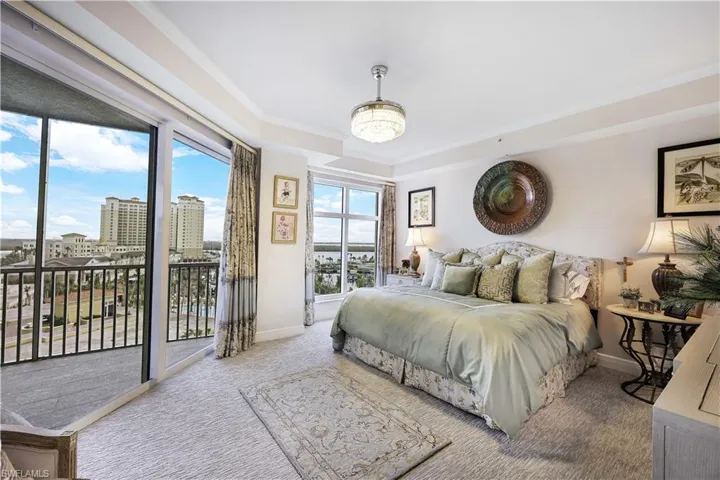 Carpeted master bedroom with crown molding, access to exterior, and a city view