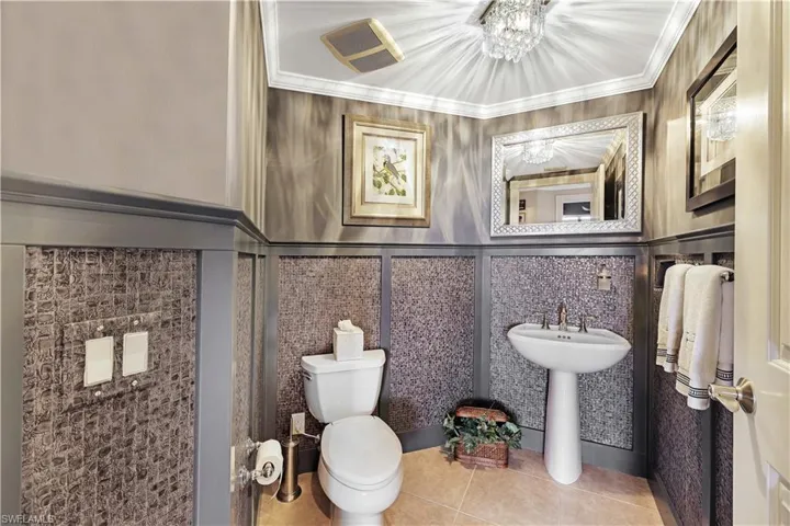 Bathroom featuring tile patterned floors and crown molding