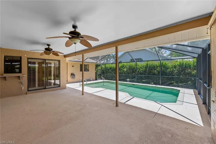 Large covered lanai with view of swimming pool and screened patio with ceiling fan