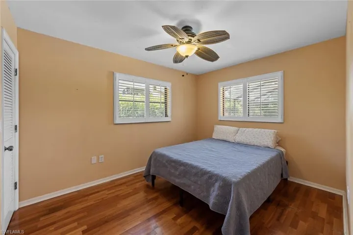 Bedroom 3 with dark hardwood / wood-style floors, a closet, and ceiling fan