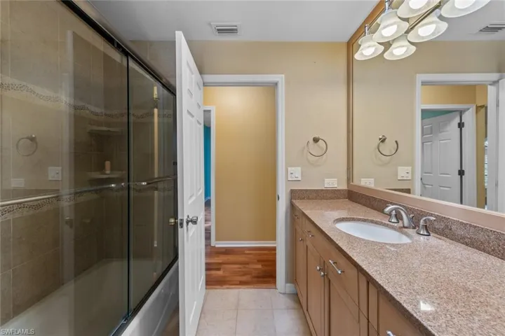 Guest Bathroom featuring tile floors, toilet, and vanity, with door to pool area