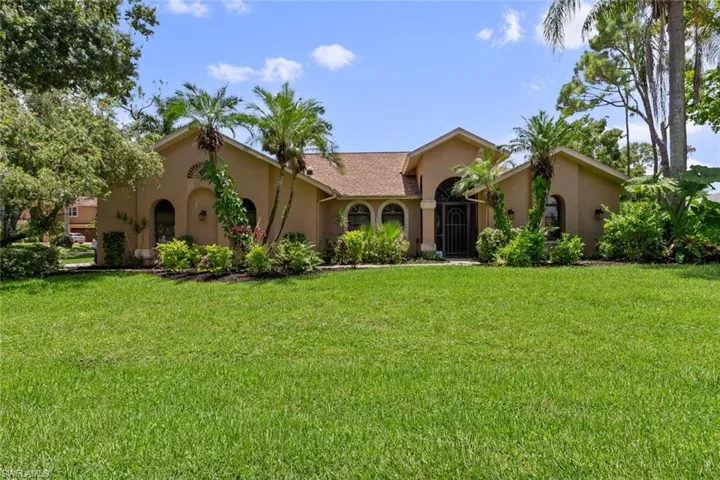 Front of the home with tropical landscaping