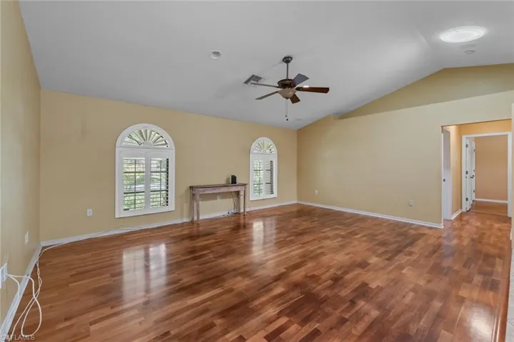 Family room with open concept to kitchen, with a wealth of natural light, and ceiling fan