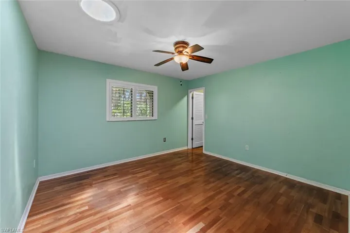Bedroom 2 featuring ceiling fan and hardwood / wood-style flooring and walk in closet