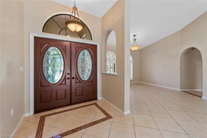 Tiled foyer featuring french doors and high vaulted ceiling