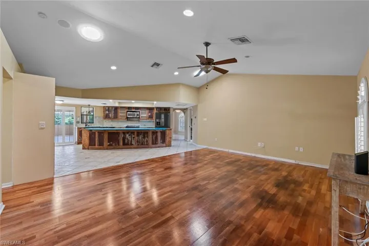 Family room with open concept to kitchen, with a wealth of natural light, and ceiling fan