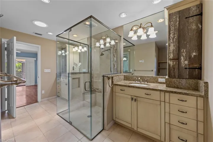 Master Bathroom featuring tile flooring, shower, dual vanity, and walk in closet