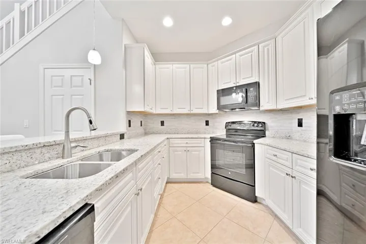 Kitchen featuring backsplash, white cabinetry, light tile patterned floors, sink, and black appliances