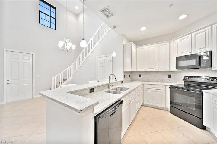Kitchen featuring tasteful backsplash, sink, black appliances, light tile patterned floors, and kitchen peninsula