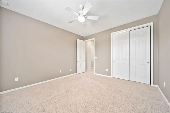 Unfurnished bedroom with ceiling fan & closet, and carpet floors