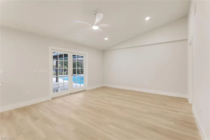 Unfurnished room with vaulted ceiling, ceiling fan, and light wood-type flooring