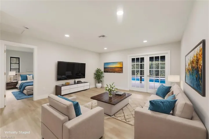 Virtually staged Living room with light hardwood / wood-style flooring and french doors