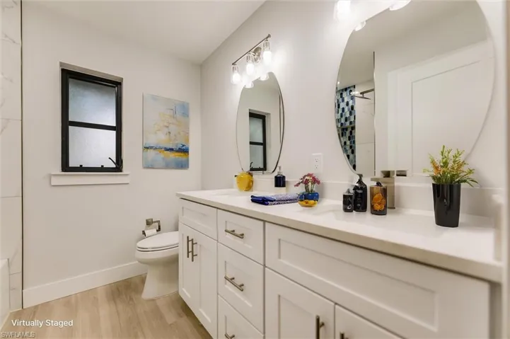 Virtually staged Bathroom featuring vanity, hardwood / wood-style floors, walk in shower, and toilet