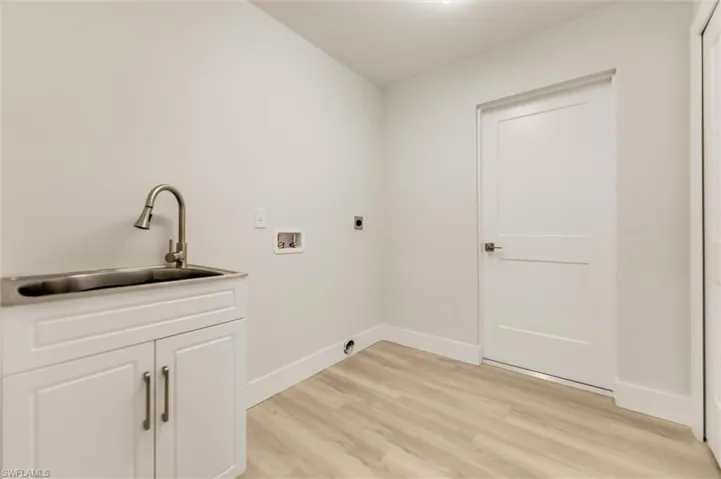 Laundry room with sink, cabinets, light hardwood / wood-style flooring, washer hookup, and hookup for an electric dryer
