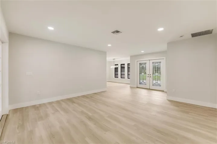Unfurnished living room featuring french doors and light wood-type flooring