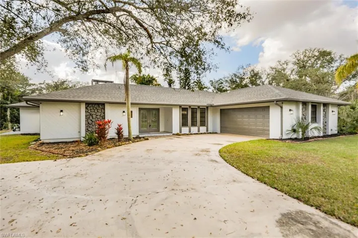 Ranch-style house featuring a garage and a front lawn