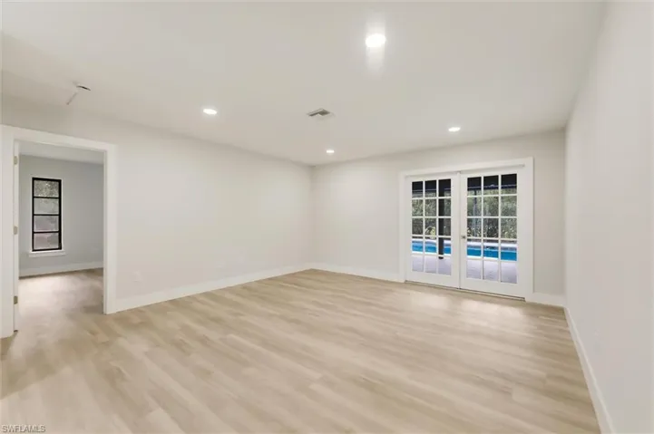 Empty room with a wealth of natural light, light hardwood / wood-style floors, and french doors