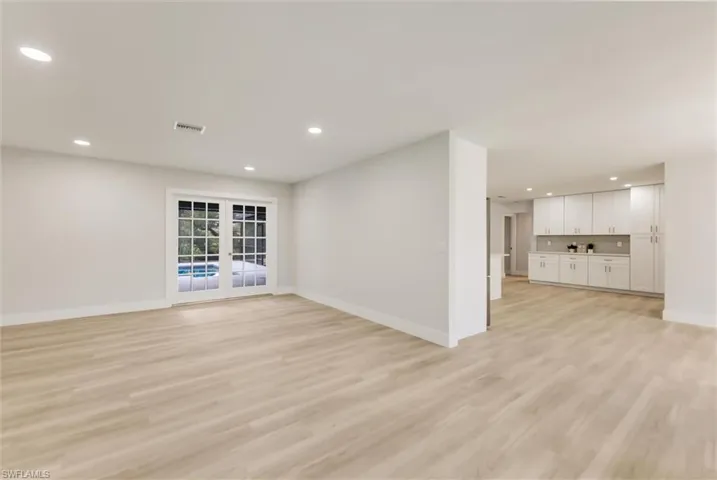Unfurnished living room with light hardwood / wood-style floors and french doors