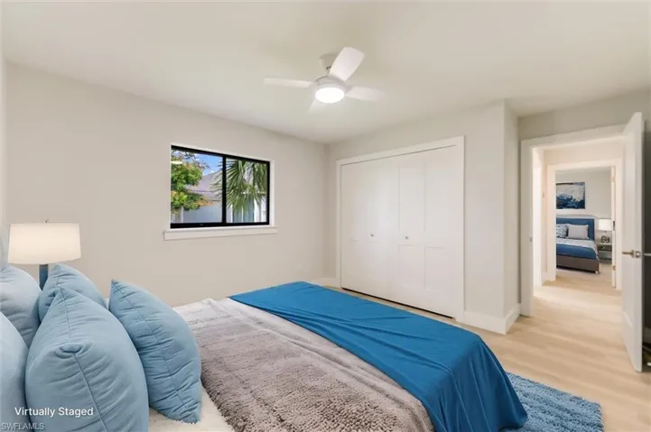 Virtually staged Bedroom featuring ceiling fan, light wood-type flooring, and a closet