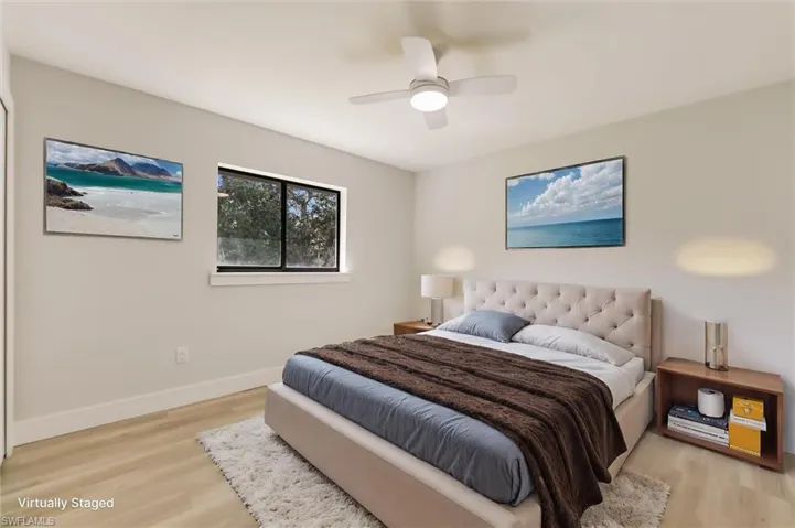 Virtually staged Bedroom with ceiling fan and light hardwood / wood-style floors
