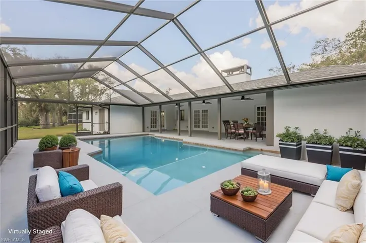 Virtually staged view of pool featuring french doors, a patio area, a lanai, ceiling fan, and an outdoor hangout area