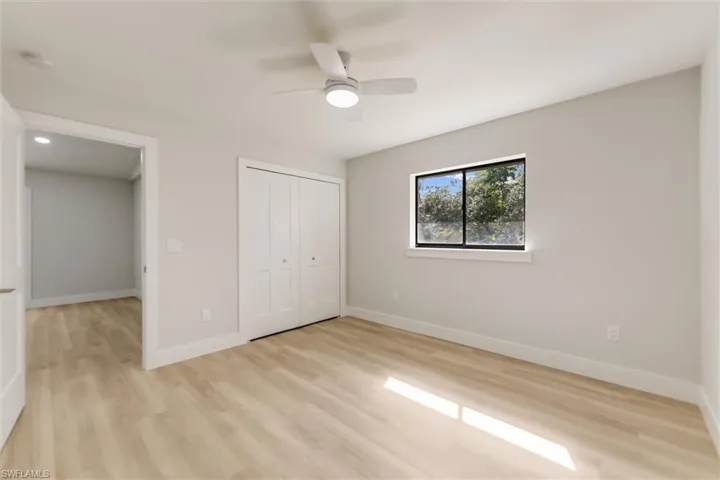 Unfurnished bedroom with light hardwood / wood-style flooring, a closet, and ceiling fan