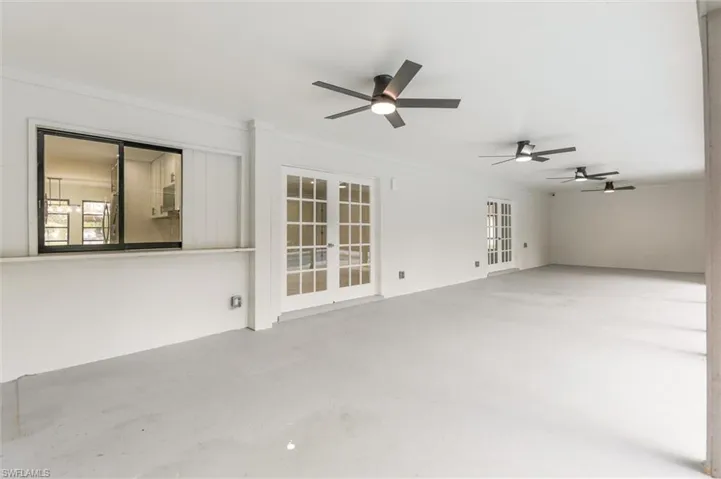 Empty room with concrete floors, ceiling fan, and french doors