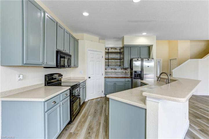 Neutral Corian Counters with large breakfast bar.