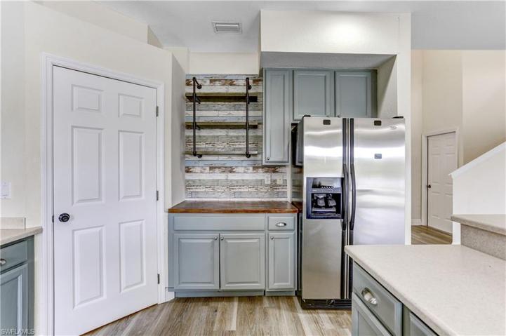 Open shelves, stainless refrigerator, plenty of cabinetry.