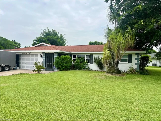 Single story home featuring a garage and a front yard