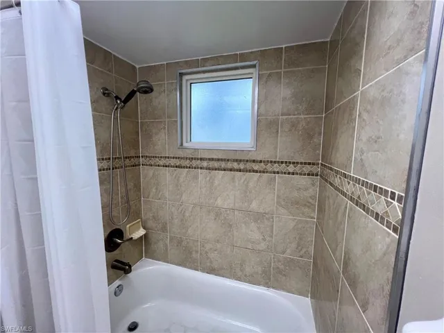 Bathroom with shower / bathtub combination with curtain