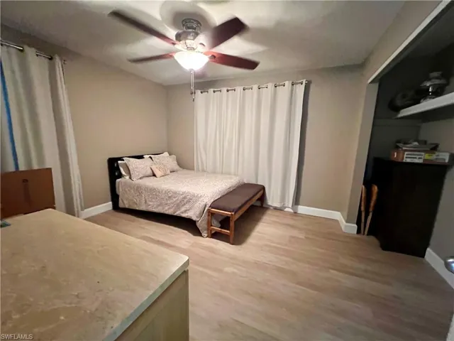 Bedroom with luxury vinyl plank flooring and ceiling fan