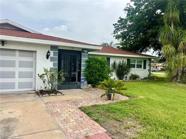 Ranch-style home featuring a garage and a front lawn