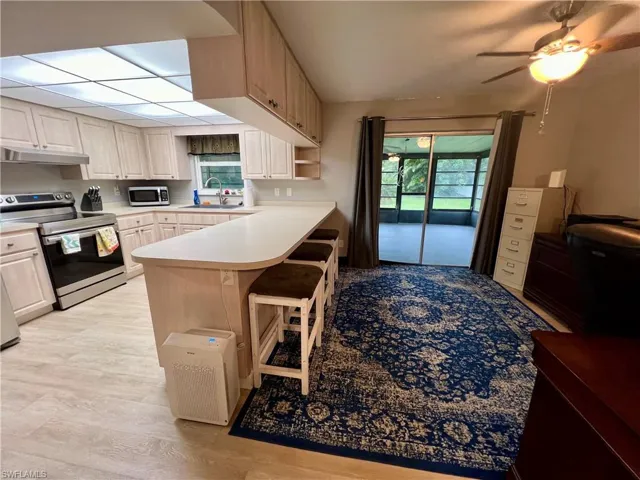 Kitchen featuring luxury vinyl plank flooring, appliances with stainless steel finishes, sink, and ceiling fan