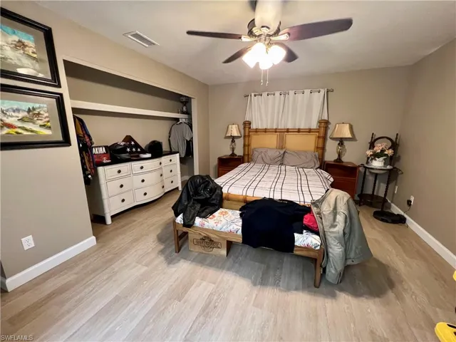Bedroom featuring luxury vinyl plank floors, a closet, and ceiling fan