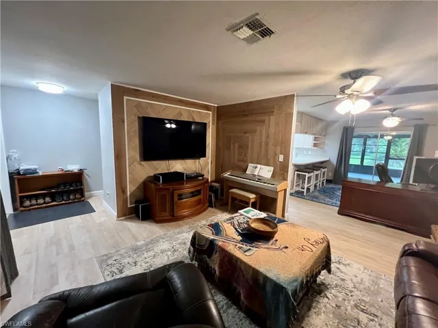 Living room with ceiling fan and luxury vinyl plank floors