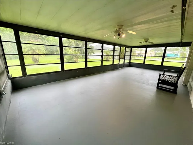Unfurnished sunroom with ceiling fan and plenty of natural light