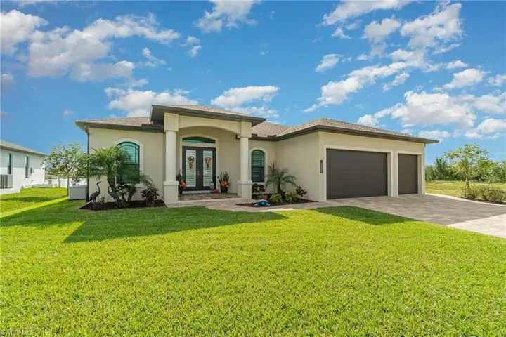 Mediterranean / spanish-style home with a front lawn, a garage, central AC, and french doors