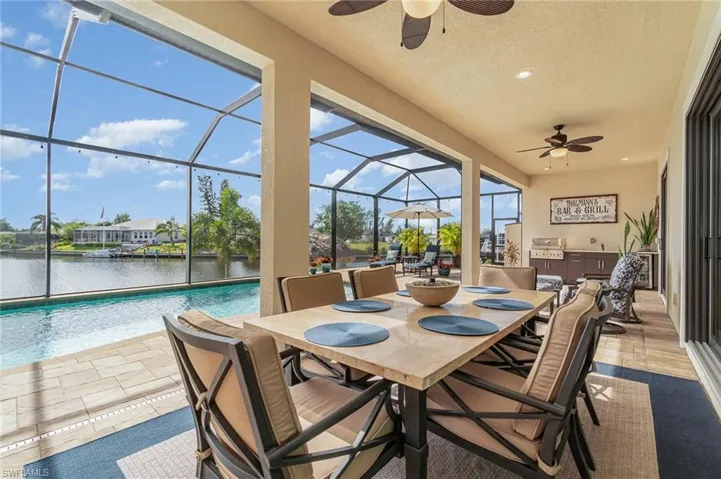 Sunroom featuring ceiling fan, a swimming pool, and a water view