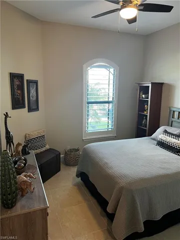 Bedroom 1 featuring ceiling fan and custom shutter
