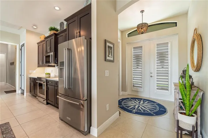 Kitchen featuring dark brown cabinetry, light tile patterned floors, and stainless steel appliances