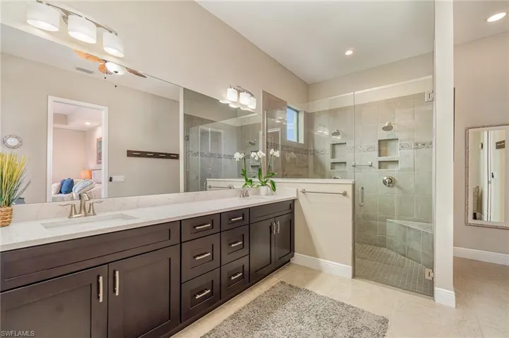 Bathroom with tile patterned flooring, vanity, and an enclosed shower