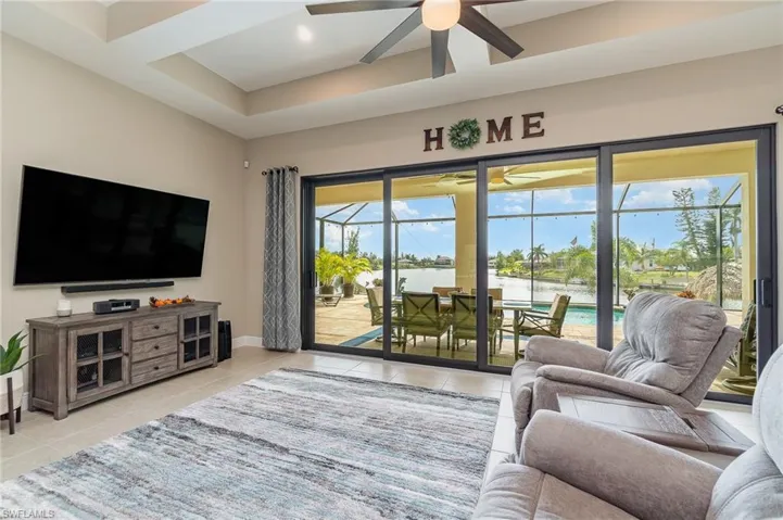 Tiled living room featuring ceiling fan and a water view