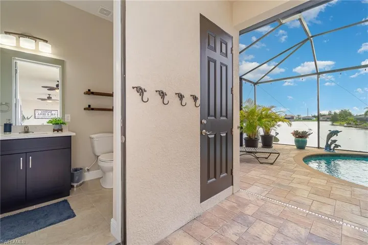 View of pool featuring ceiling fan, a water view, and a jacuzzi