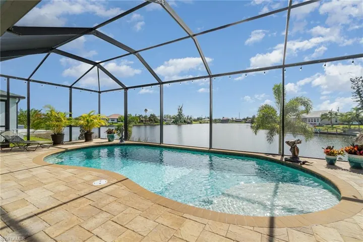 View of pool with a lanai, a water view, and a patio