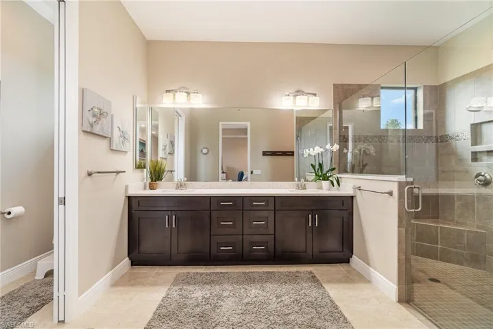 Bathroom with tile patterned floors, vanity, and walk in shower