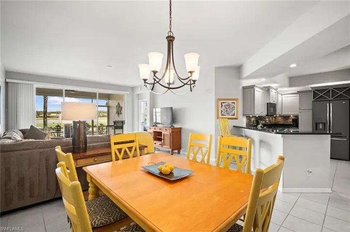 Dining area with light tile patterned floors, a chandelier, recessed lighting, and baseboards
