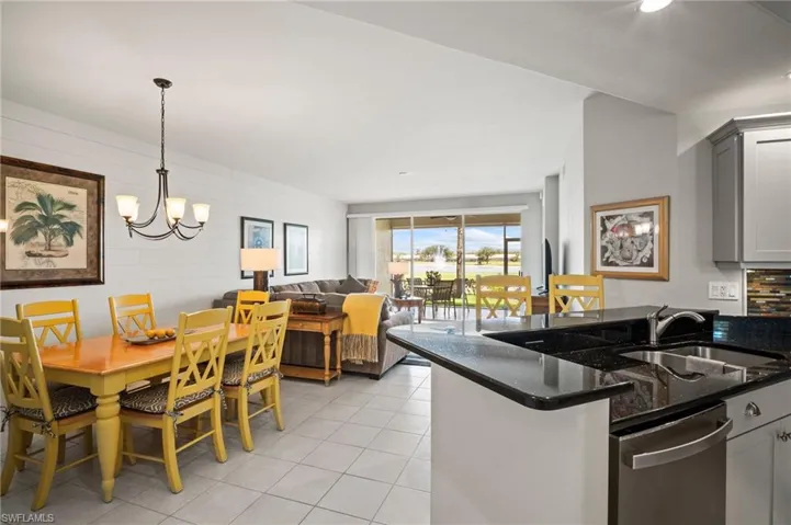 Kitchen with a sink, stainless steel dishwasher, light tile patterned floors, dark stone countertops, and gray cabinets