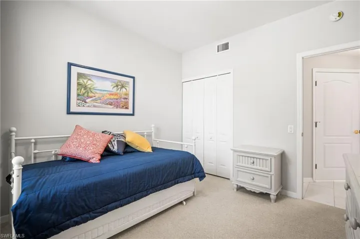 Bedroom featuring light colored carpet, a closet, and baseboards