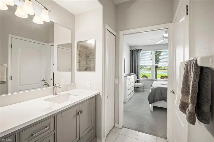 Bathroom featuring ensuite bathroom, vanity, tile patterned flooring, and ceiling fan